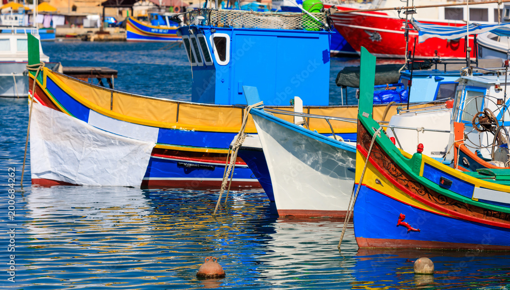 Marsaxlokk fishermen village in Malta. Traditional colorful boats at the port of Marsaxlokk. Closeup view