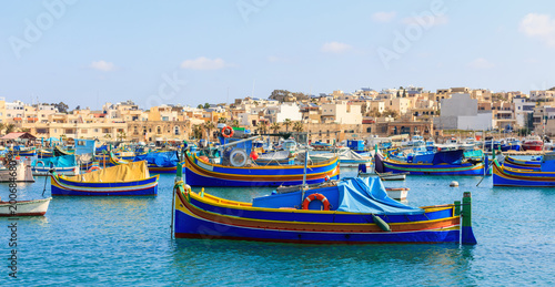 Marsaxlokk fishermen village in Malta. Traditional colorful boats at the port of Marsaxlokk photo