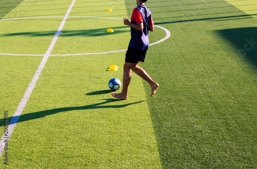 sport, football training and Kid - soccer player playing and juggling with ball on field. © Fotoglee