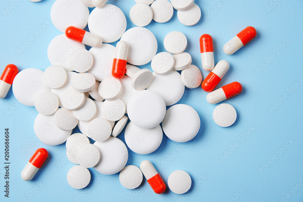 Assorted pharmaceutical medicine pills, tablets and capsules on blue background. Assorted pharmaceutical medicine pills, tablets and capsules on blue background.