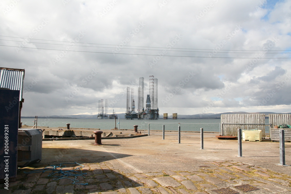 Obraz premium Cromarty Harbour overlooking oil rigs in the Firth. Black Isle, Scotland