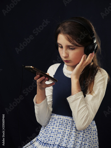 Teenager listening music in headphones, smartphone as a media carrier, 