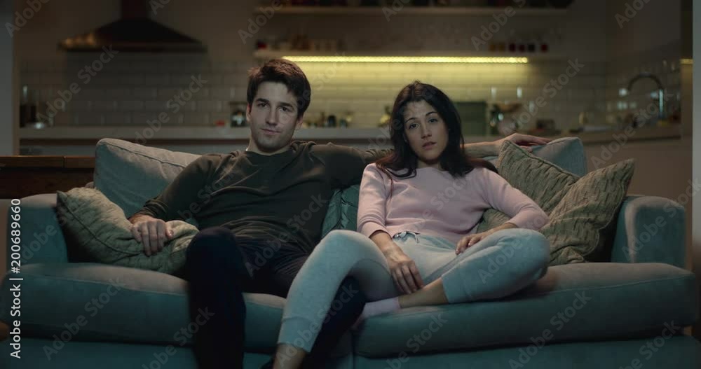 Couple watching tv at home in the evening. Couple watching tv at home in the evening.