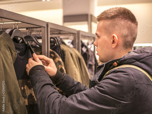 portrait of man picking up clothes in the store