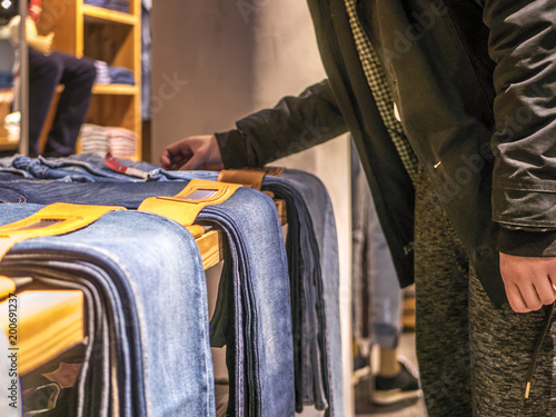 close up person's hand picking and buying jeans in the store