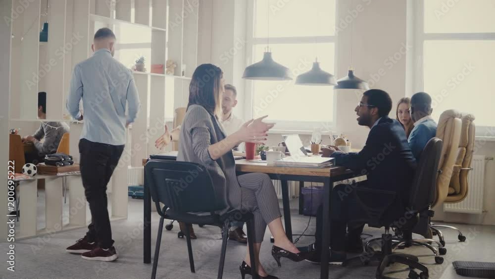 Dolly shot of teamwork at loft modern office table. Multiethnic business people cooperate, discuss market at meeting 4K. Dolly shot of teamwork at loft modern office table. Multiethnic business people cooperate, discuss market at meeting 4K.