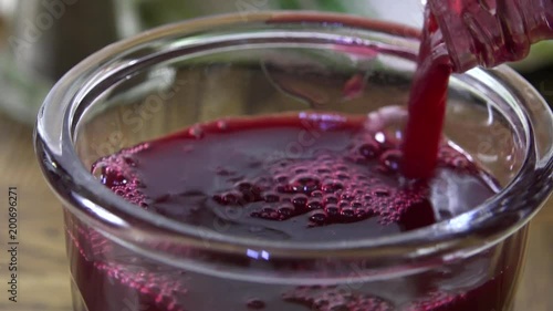 Pouring cranberry juice into a glass slow motion