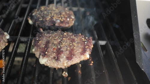 slider shot of hamburgers cooking on a grill