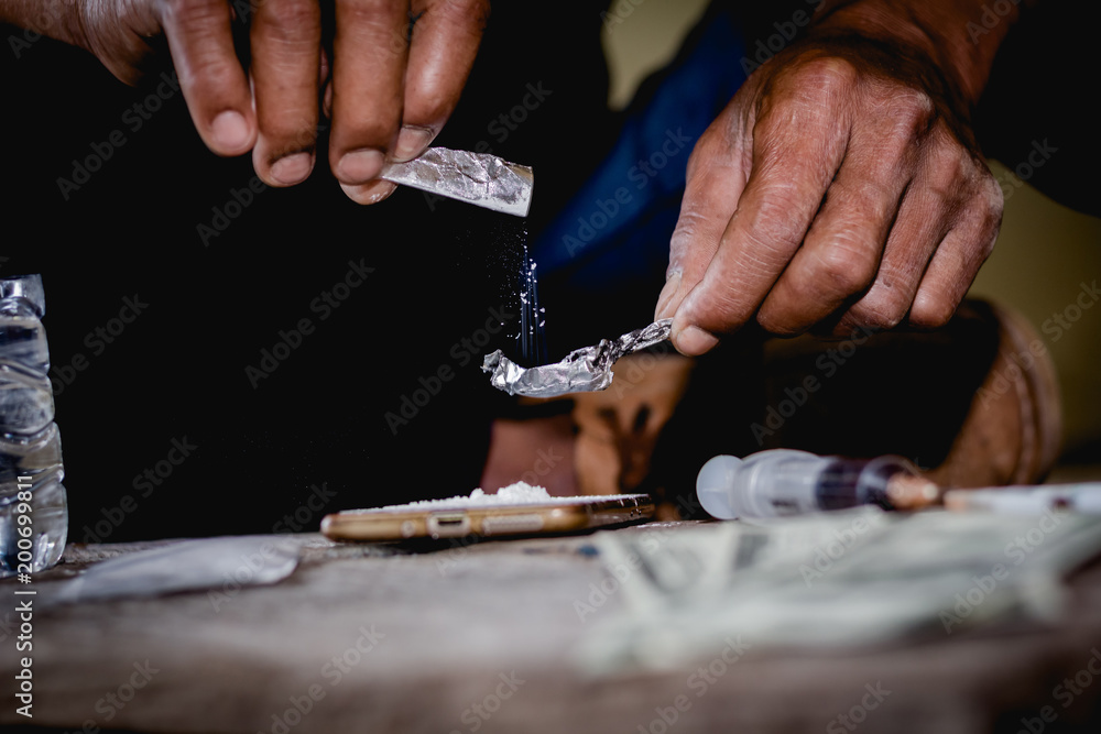 Closeup man using heroin. Narcotic overdose.man addict using cocaine drugs.Drug heroin addiction.Drug abuse concept, - obrazy, fototapety, plakaty 