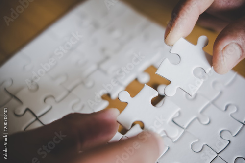 Man hands connecting couple puzzle piece in office. Business solutions, target, successful, goals and strategy concepts