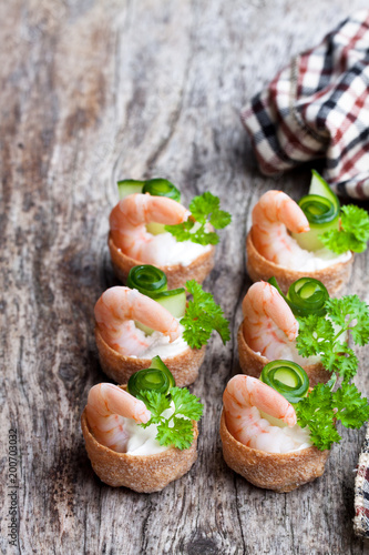 Salted  croustades crispy pastry stuffed with cream cheese and prawns on wooden table photo