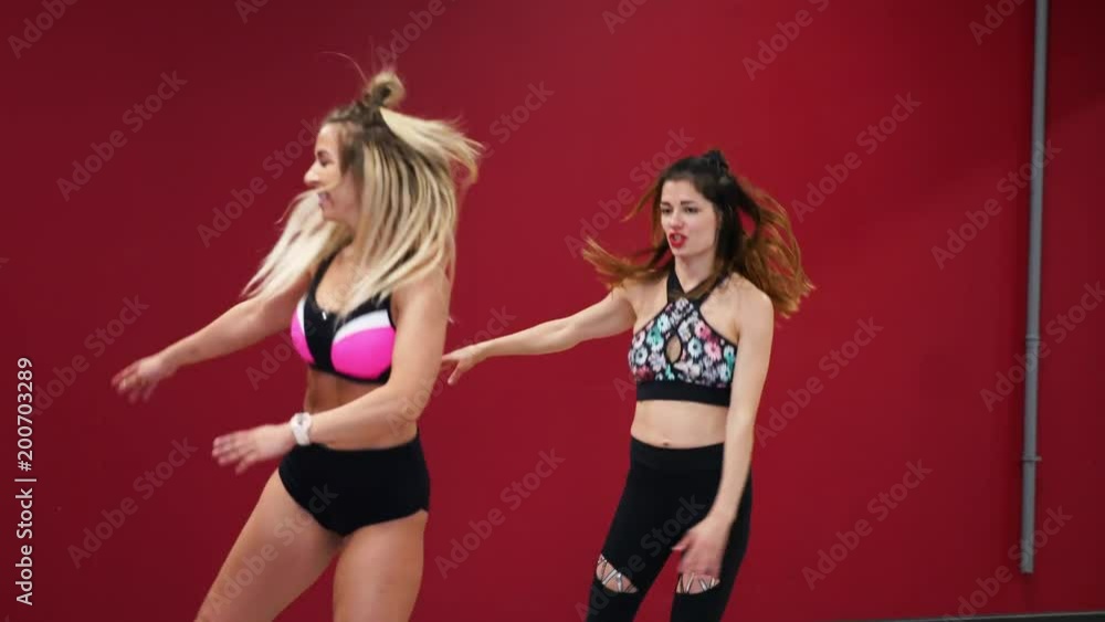 Two beautiful sports girls perform an active fat-burning workout jumping like a kangaroo in special fitness shoes. Cardio workout for endurance. kango jump Two beautiful sports girls perform an active fat-burning workout jumping like a kangaroo in special fitness shoes. Cardio workout for endurance. kango jump