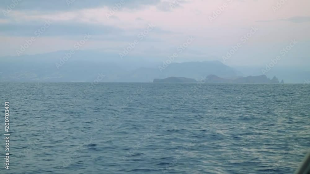 View of Madeira island in fog from board of sailing yacht View of Madeira island in fog from board of sailing yacht