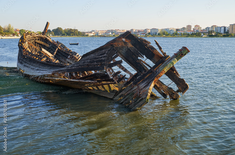 Old skeleton of a destroyed and burned boat on the bank of the Seixal Bay. Lisbon. Portugal