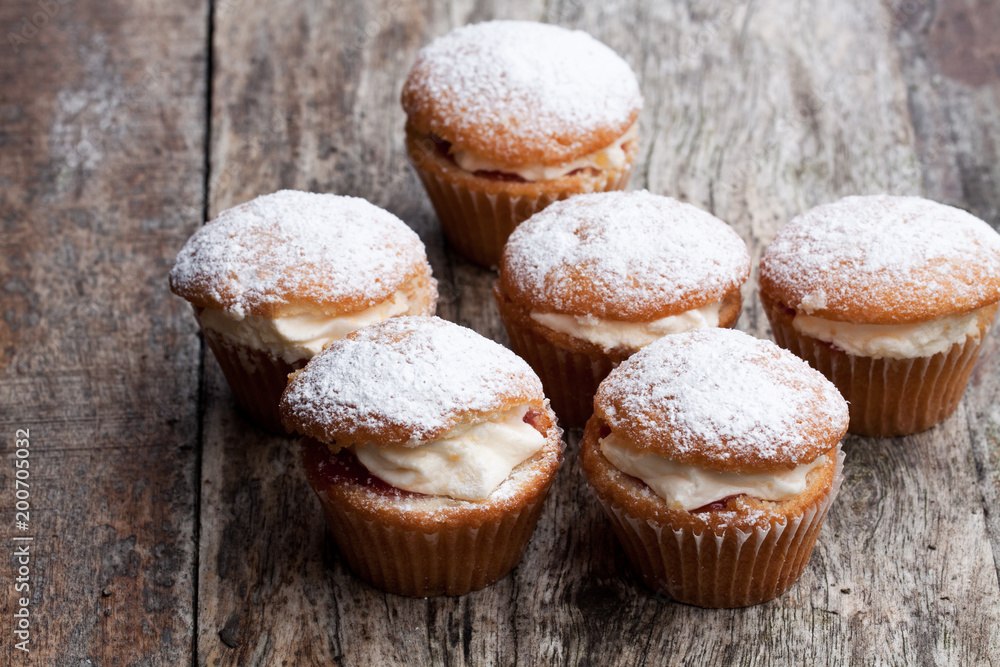 Cupcakes stuffed with white cream on wooden table Cupcakes stuffed with white cream on wooden table