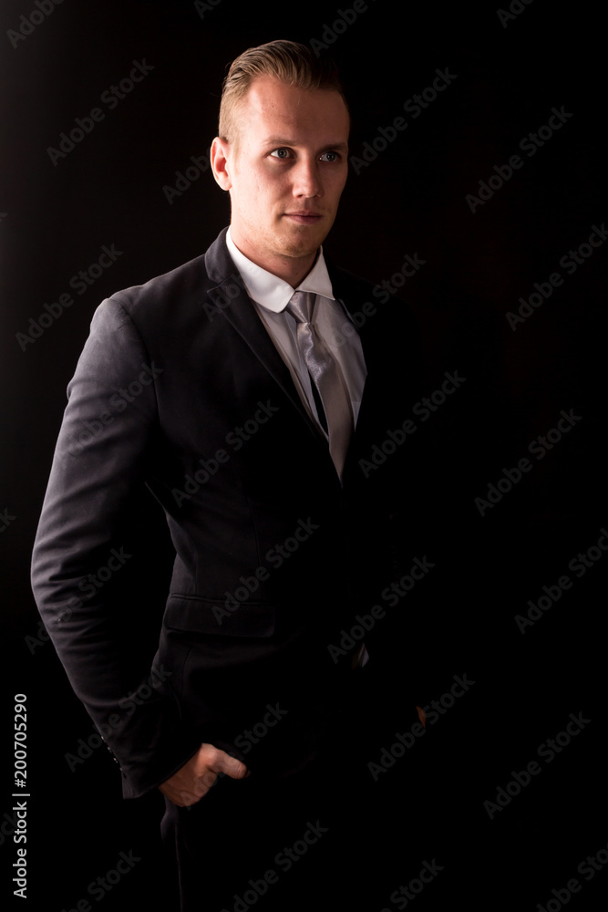 Handsome Businessman with black suit isolated on black background
