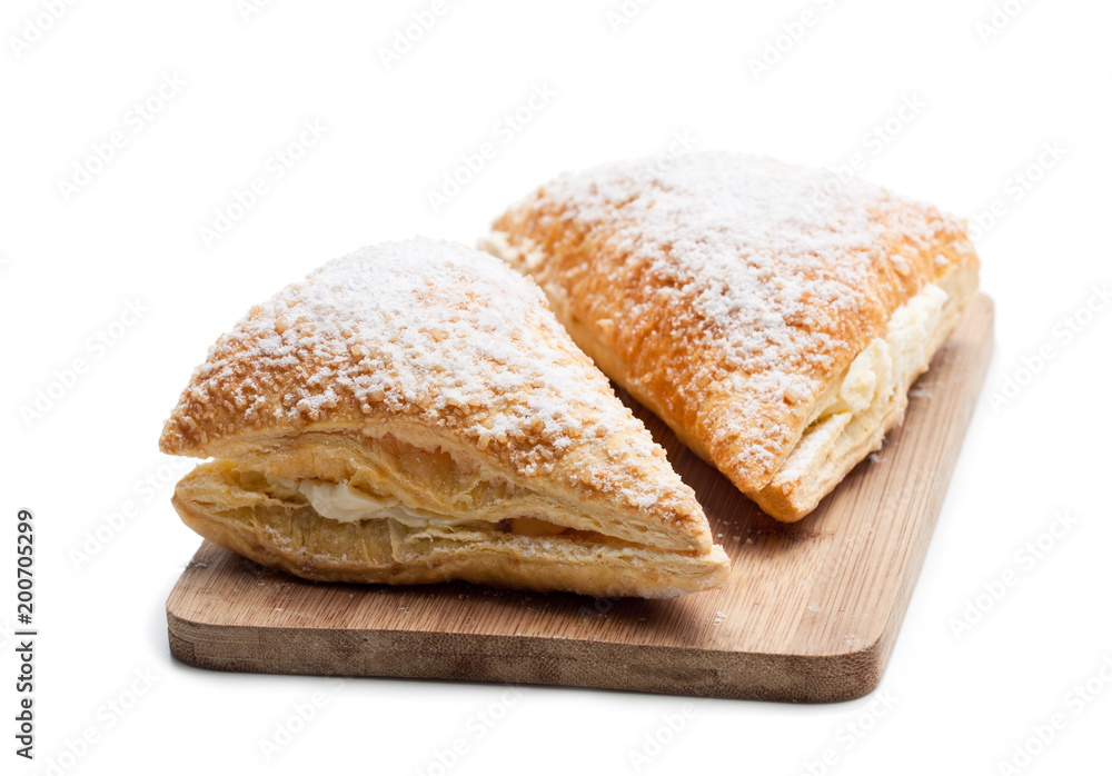 Two  freshly baked turnovers with white cream isolated on white