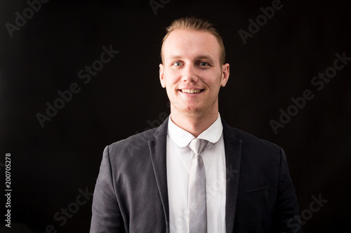 Handsome Businessman with black suit isolated on black background