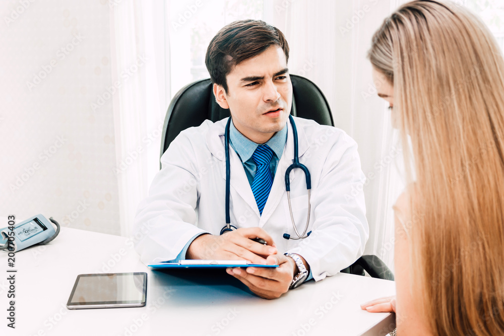 Doctor discussing and consulting with female patien on doctors table in hospital.healthcare and medicine Doctor discussing and consulting with female patien on doctors table in hospital.healthcare and medicine