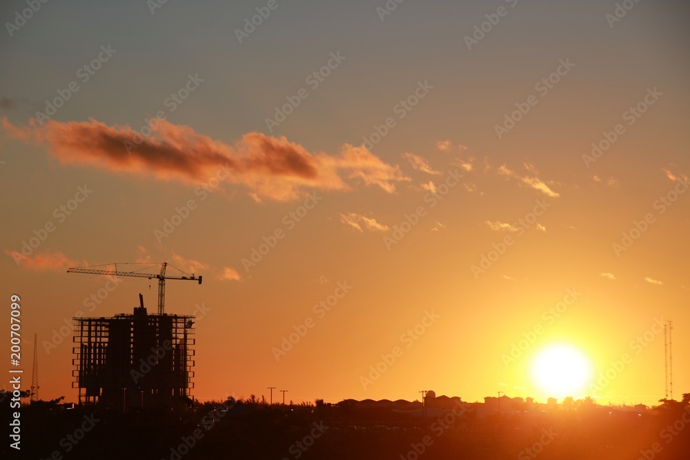 Skeleton of Building with Crane Scaffolding Under Construction at Sunset with Mostly Clear Sky a Few Scattered Orange Clouds Skeleton of Building with Crane Scaffolding Under Construction at Sunset with Mostly Clear Sky a Few Scattered Orange Clouds