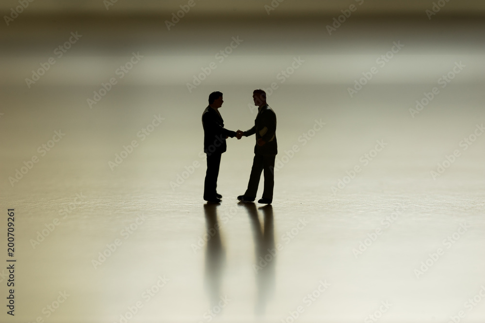 scenic of silhouette mini businessman shake hand for business deal scenic of silhouette mini businessman shake hand for business deal