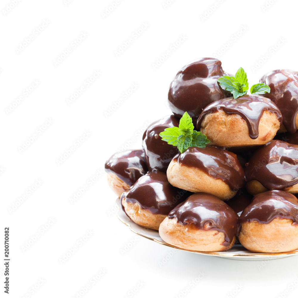 Homemade profiterole choux with chocolate ganache on the plate isolated Homemade profiterole choux with chocolate ganache on the plate isolated