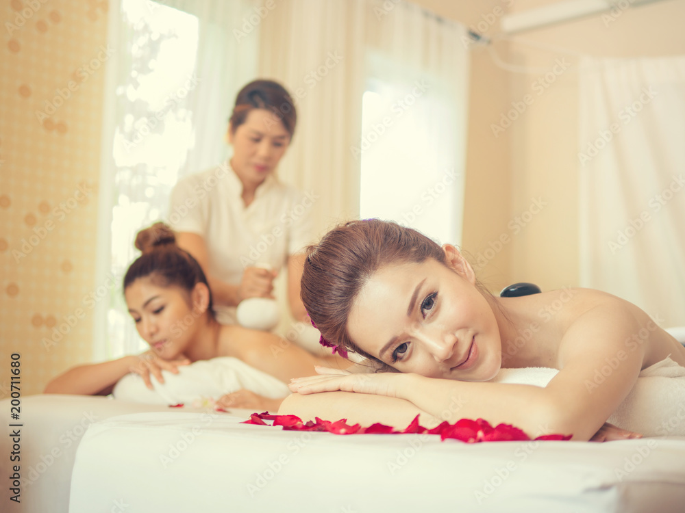 Obraz premium Young Asian woman brunette skin relaxing in spa.young woman lying down on massage beds at Asian luxury spa and wellness center