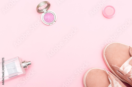 Pink sneakers and accessories on a pink background. Copy space