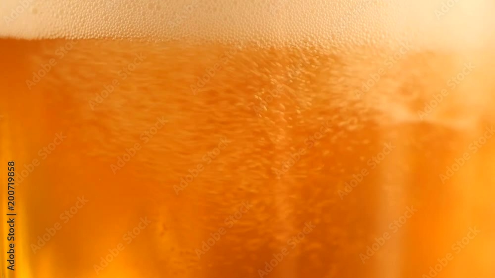 Detail of beer glass with bubbles. Close up beer background, slow motion. Detail of beer glass with bubbles. Close up beer background, slow motion.