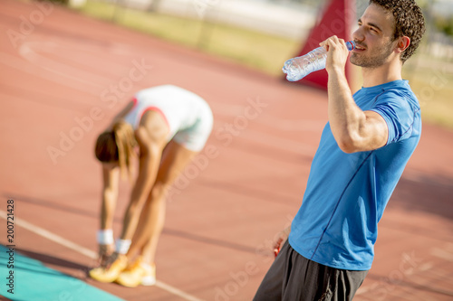 Sporty man drinking water w...