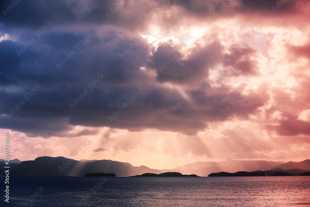 Norway, sun beams in colorful dramatic sky