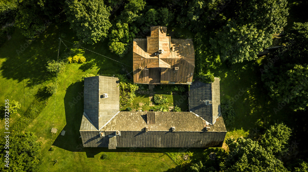 Aerial view from drone on one house in countryside located among the trees. Roof top view.