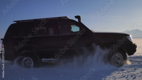 Car drive on the ice road over lake
