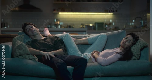 Man and woman slumped in front of the tv.