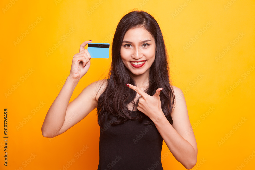 Young Asian woman point to a blank card. Young Asian woman point to a blank card.
