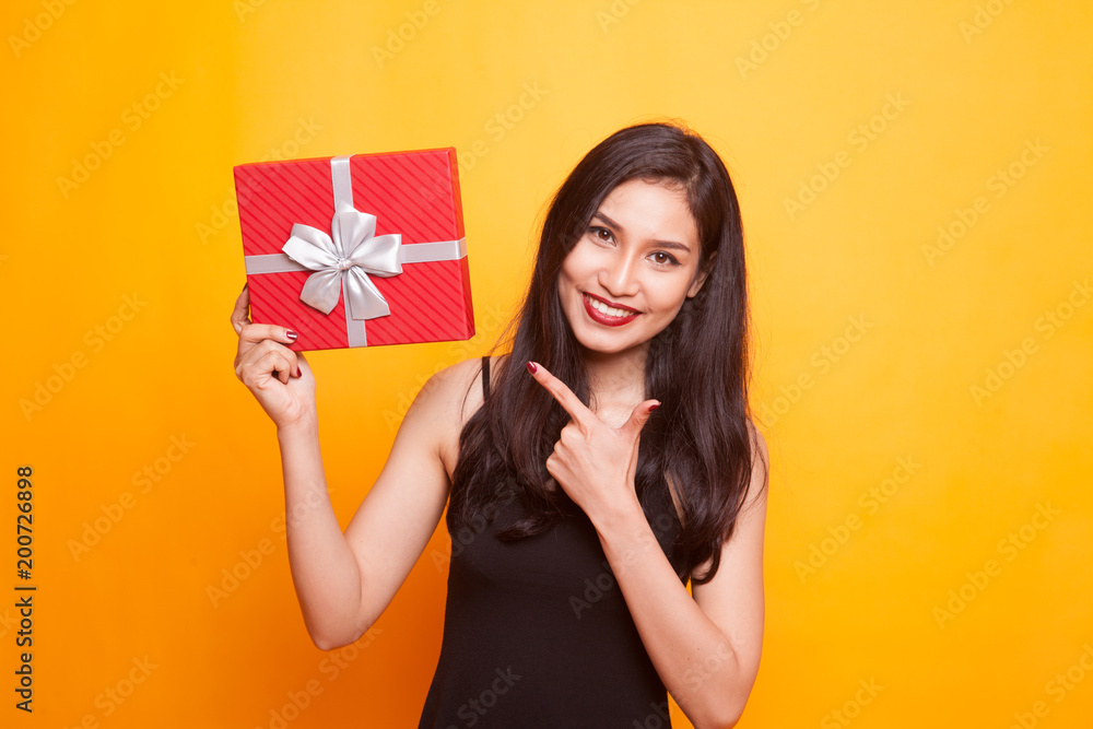 Young Asian woman thumbs up with a gift box. Young Asian woman thumbs up with a gift box.