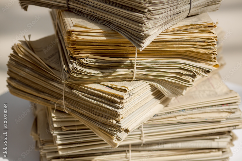 Obraz premium Archive with old newspapers close-up. Pile of unsold newspapers, selective focus.