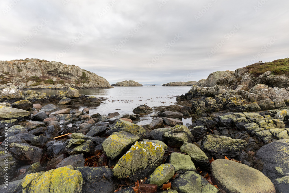 Rocks covered in lichen, the ocean and islands in the background. Urd island at the Rovaer archipelago in Haugesund, norwegian west coast.