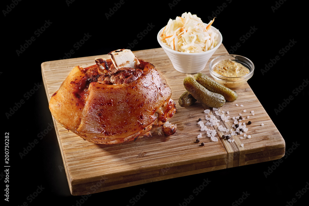 Φωτογραφία close-up view of tasty roasted pork knuckle with sauces on wooden board