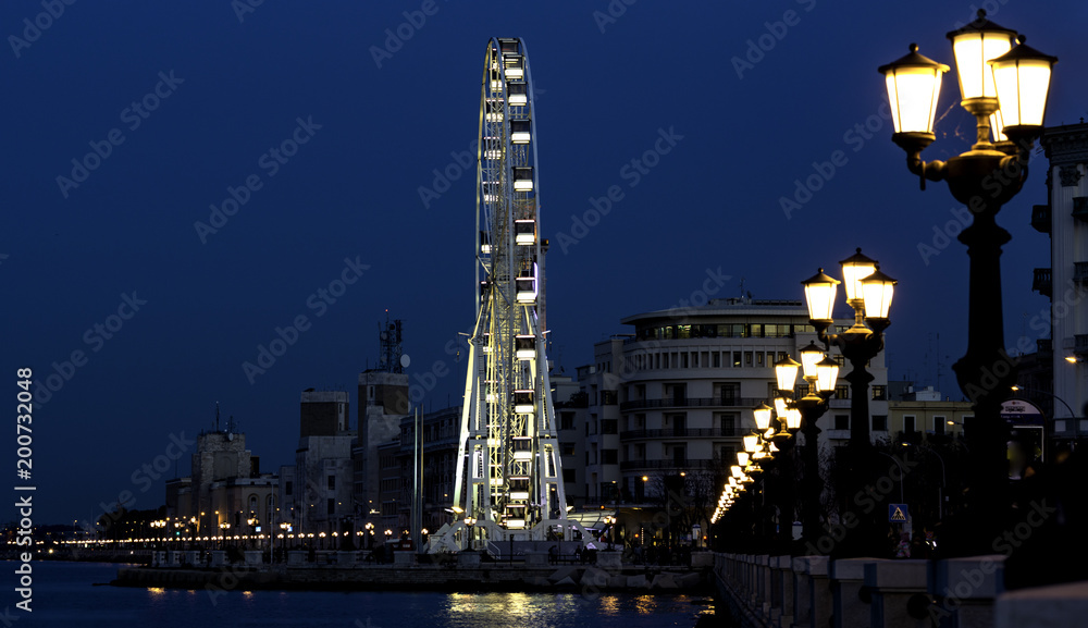 Big ferris wheel lit up on the waterfront of Bari with the lights turned on