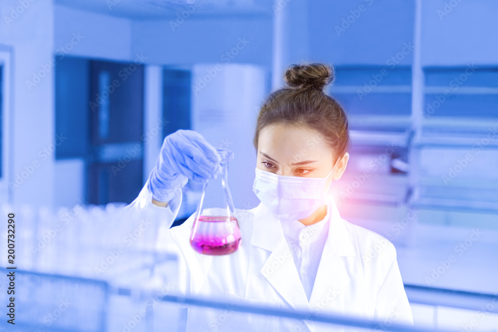 Female scientist looking at the scientific sample in the laboratory Female scientist looking at the scientific sample in the laboratory
