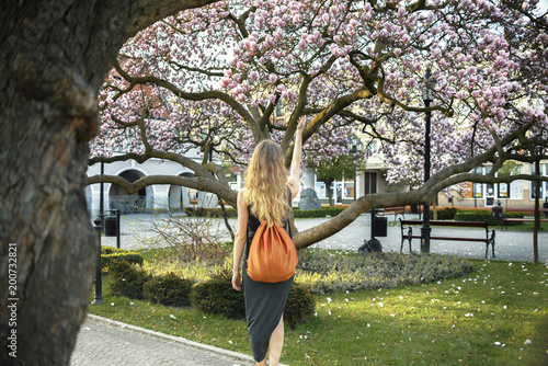 Woman in a grey dress and orange bag is walking on the street in Kluczbork, Poland photo