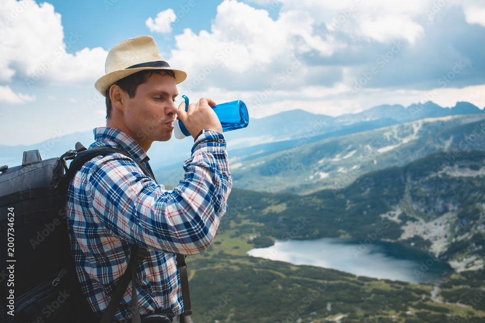 Traveler drinks water in the mountains