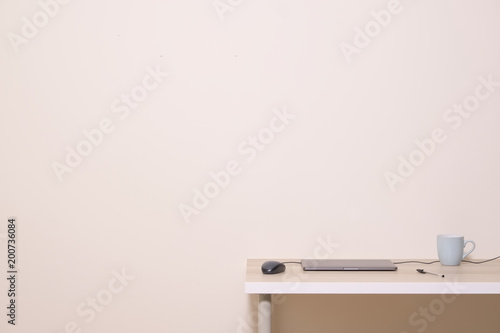 Blank office desk work background empty wall laptop cable mouse pen cup mug