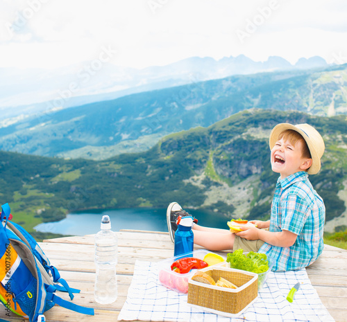 Little boy on a picnic in the mountains photo