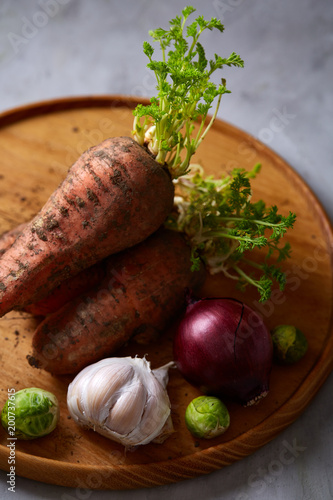 Colorful various of organic farm vegetables with fresh carrots on wooden rustic background, top view, selective focus