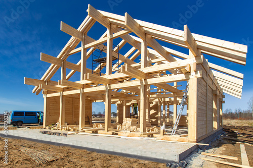 Construction of a house made of laminated veneer lumber. The frame of the house. Cottage made of laminated wood. Erection of the frame of the cottage. Manufacture of houses made of wood. © Grispb