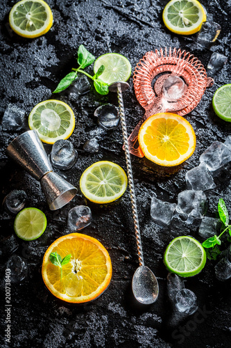 Bartender accessories with spoon, strainer and measure on black rock