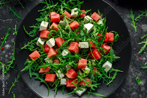 Fresh Juicy Watermelon arugula Feta salad with mint and orange, lemon dressing. summer dish. healthy food