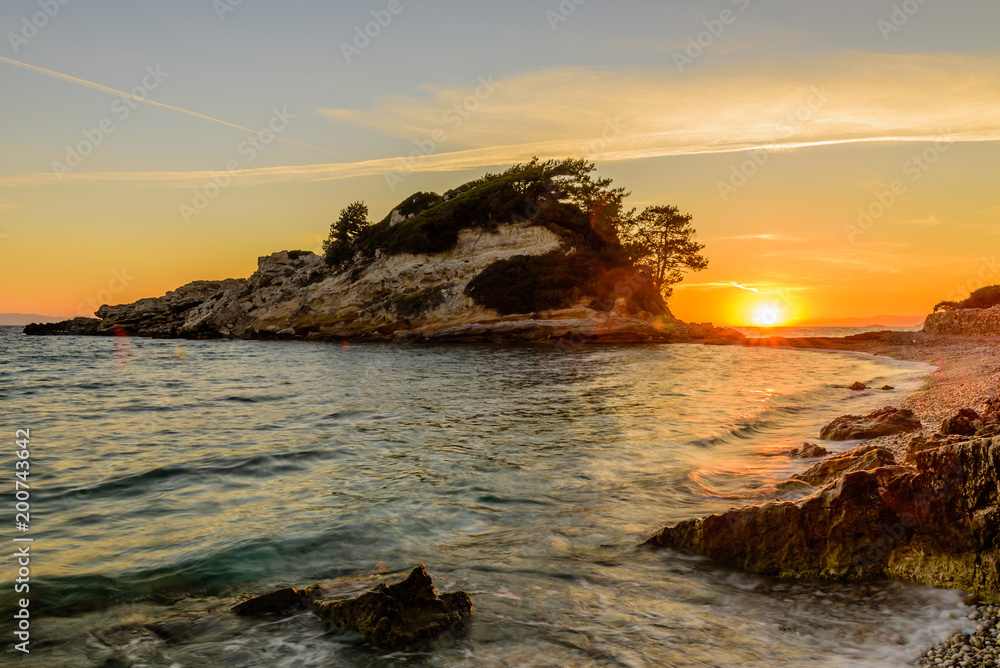 Beautiful sunrise on the sea. The picturesque beach in Kokkari village, Samos island, Greece.